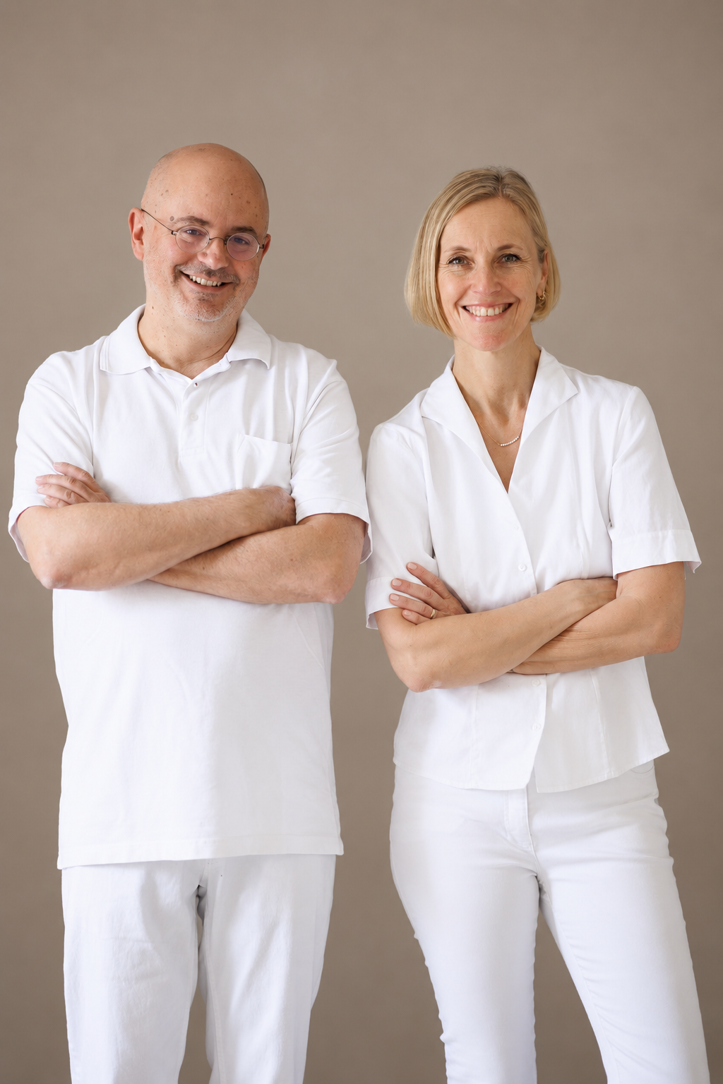 Dr. Patrick Schmidt und Dr. Simone Kröll stehen lächelnd nebeneinander in einem hellen Raum der Ordination