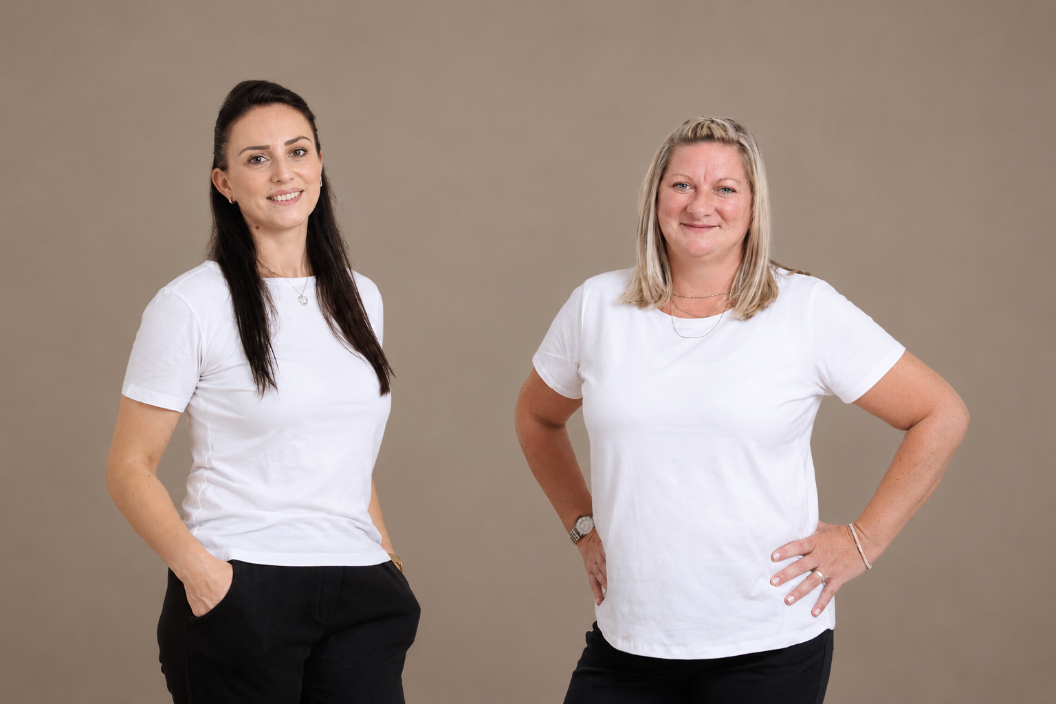 Die beiden Mitarbeiterinnen der Raumpflege stehen in weißen T-Shirts nebeneinander